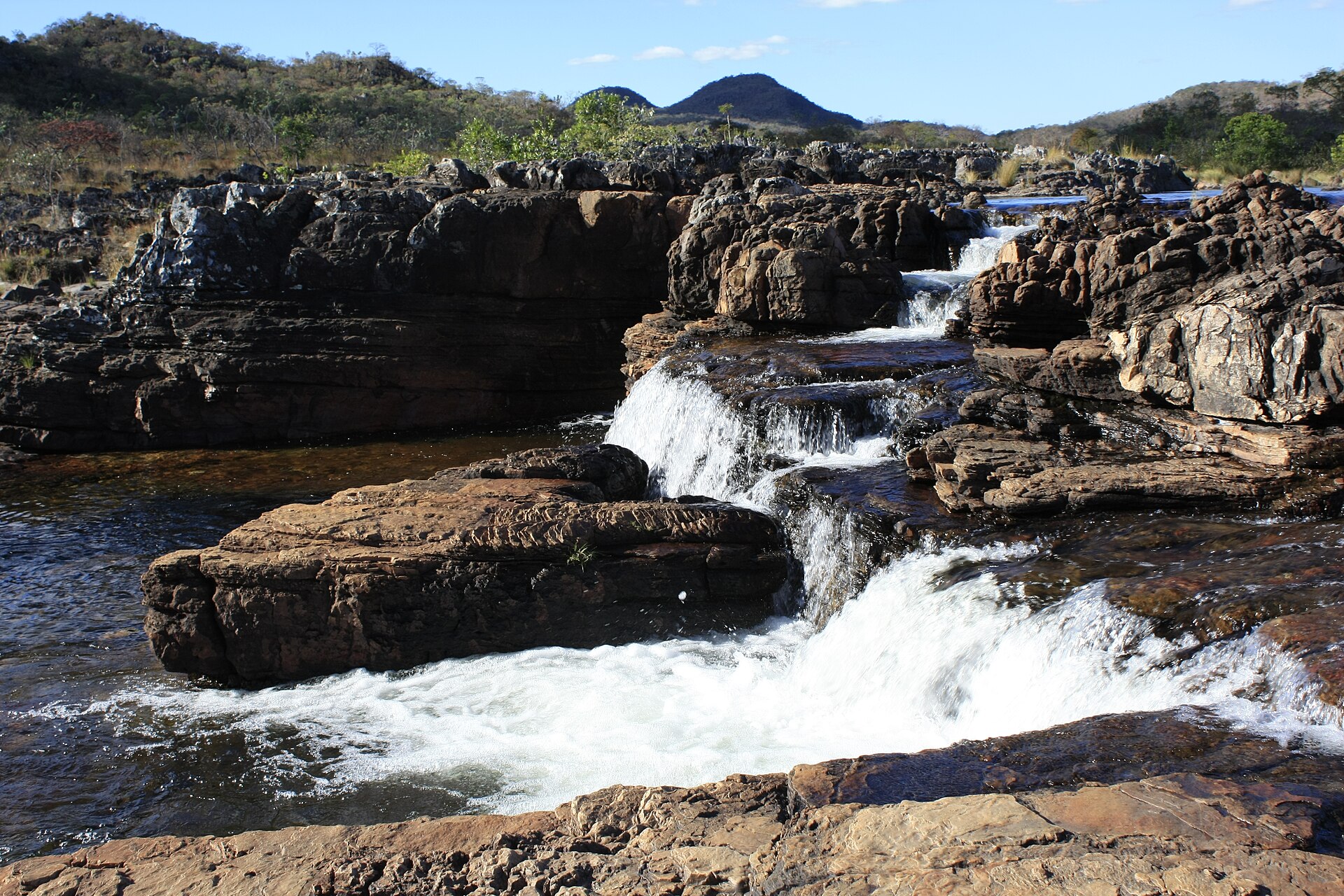 Água do Rio Preto correndo em pequenas quedas por rochas escuras